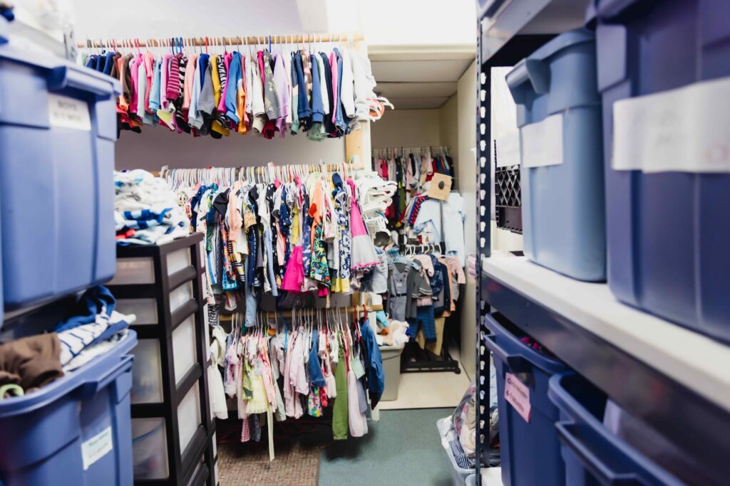 closet with children's clothes and bins